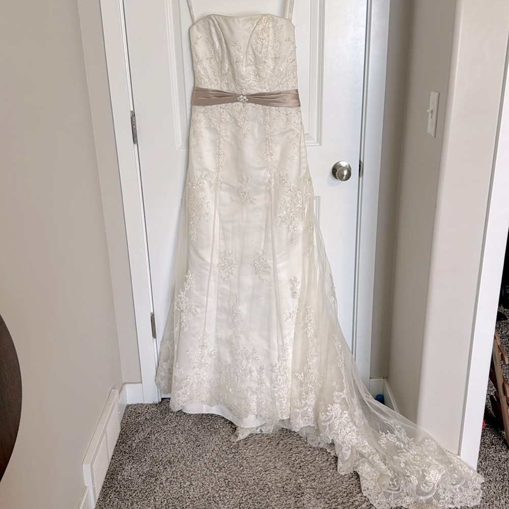 Alfred Angelo ivory wedding dress with beige ribbon accent.